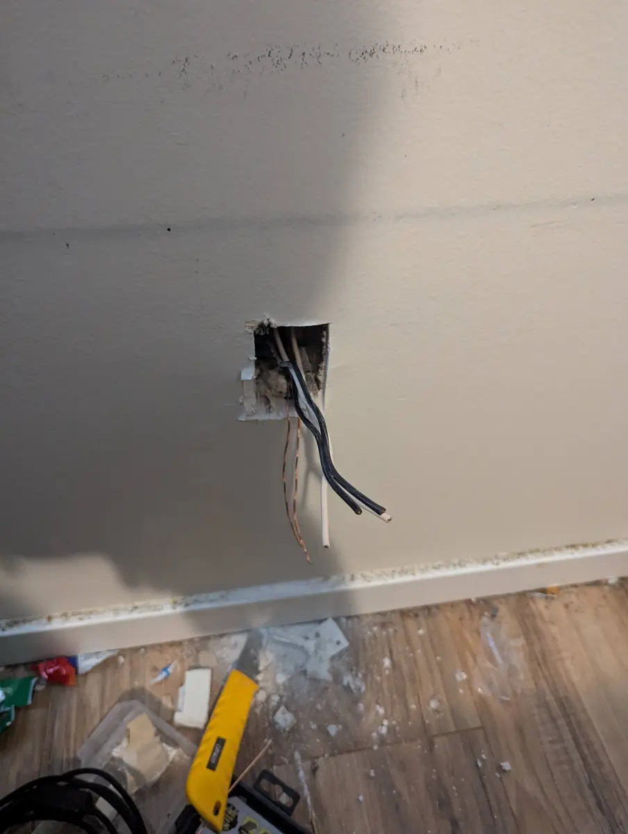 Live wires pulled from the junction box that was buried behind drywall, Prince George basement renovation