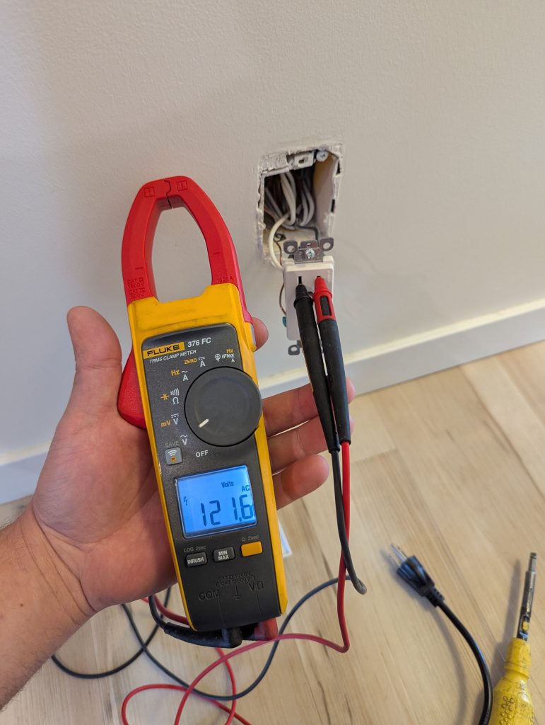 Testing a circuit with a Fluke clamp meter during electrical troubleshooting
